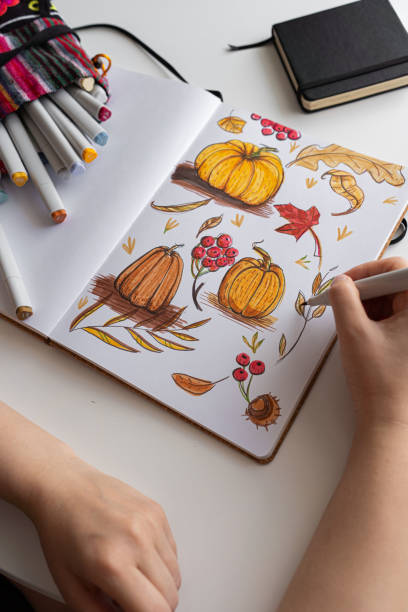 istock Hand drawing colorful autumn-themed illustrations in sketchbook 2170506570