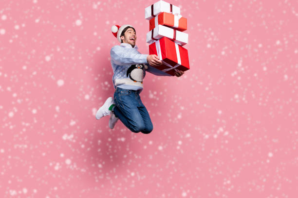 istock Photo of impressed cute man dressed blue christmas pullover jumping holding presents pile smiling isolated pink color background 2170508665