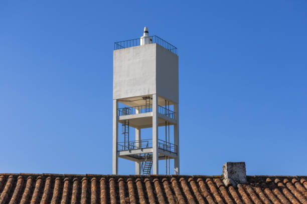 Square white water tower and roof of a house in a village of Portugal