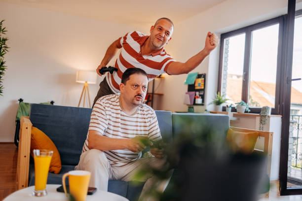 istock Middle age men having fun at home playing video games together 2170511880