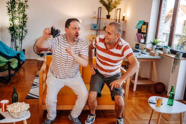 istock Middle age men having fun at home playing video games together and celebrating win 2170512471