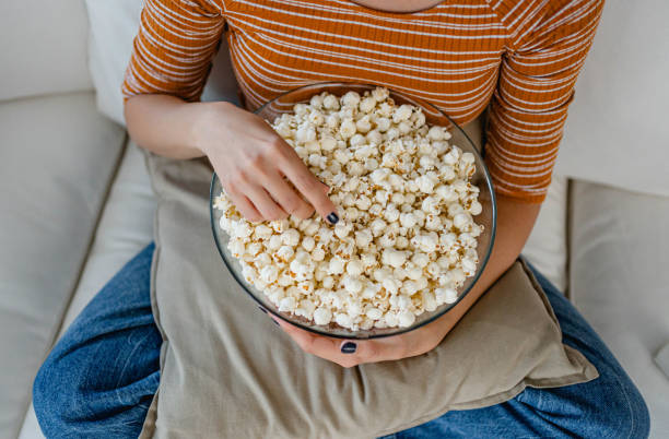 istock Woman eating popcorn at home 2170515223