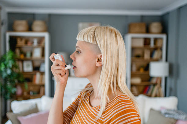 istock Young woman using an asthma inhaler 2170515288