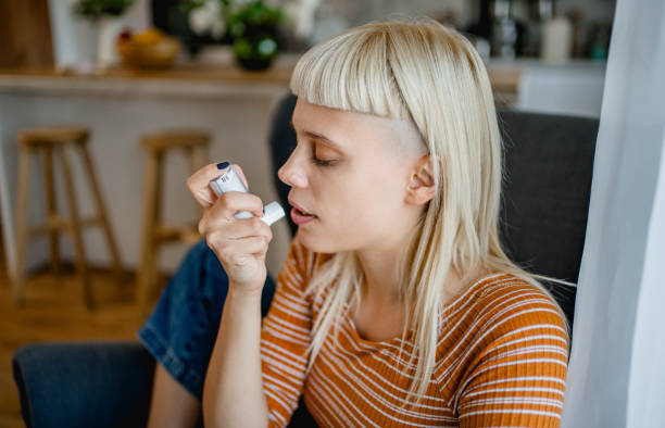 istock Young woman using an asthma inhaler 2170515357