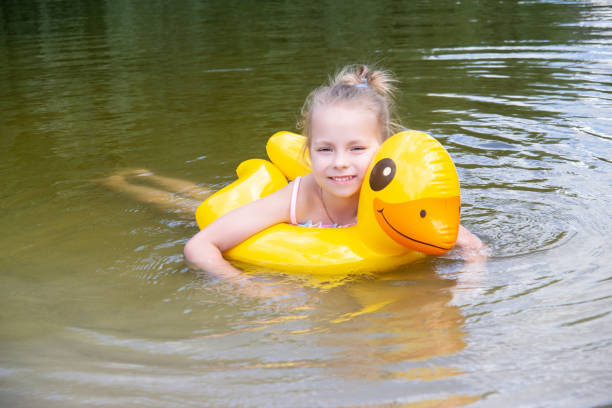 a girl swims on an inflatable circle on the lake