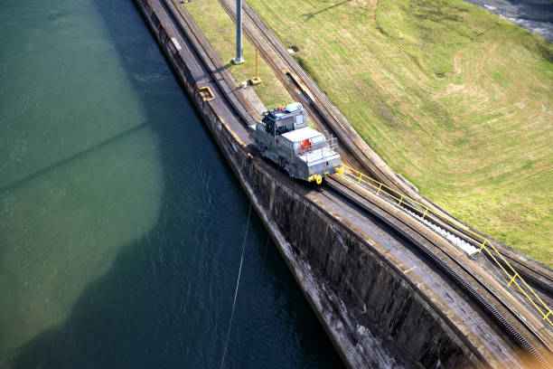 Electric Mule on railway track on top of concrete wall along Panama Canal guiding nautical vessels through Gatun locks.