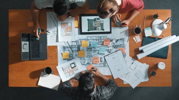 istock Top down view of engineer handed document while looking at blueprint. Symposium. 2170524338