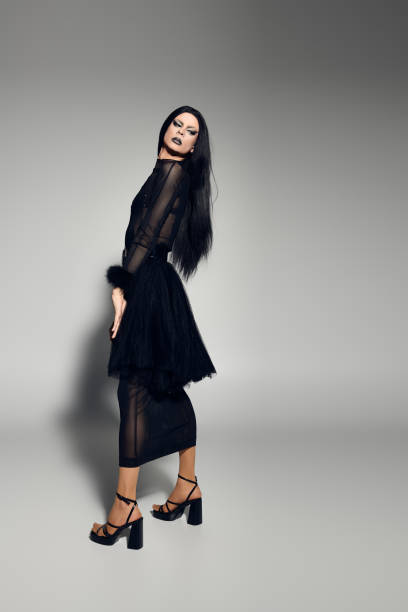istock A stunning drag queen poses elegantly in a striking black outfit against a gray backdrop 2170526021
