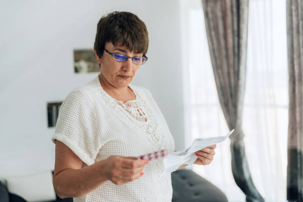 Mature woman checking the characteristics of her medicine stock photo