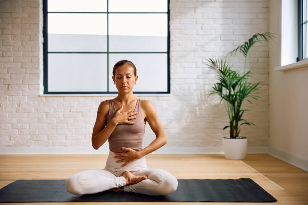 istock Calm woman using Pranayama breathing technique while practicing Yoga. 2170530796