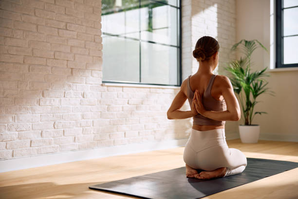 istock Rear view of woman practicing Yoga with hands clasped behind back. 2170530839