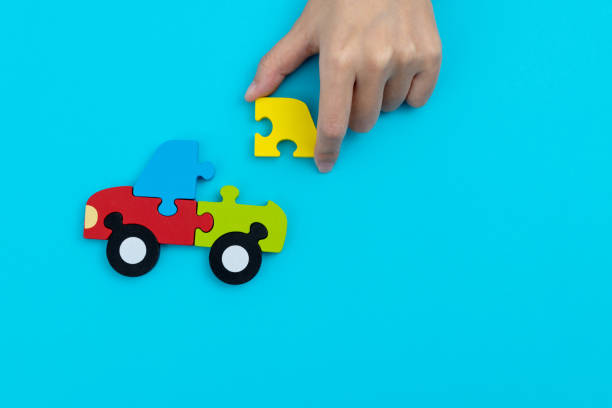 Human hand playing a jigsaw puzzle car.