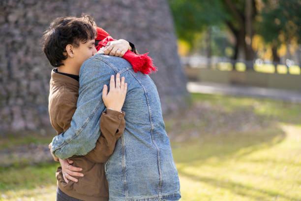 istock Young gay couple hugging in a park 2170533651
