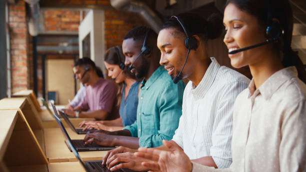 istock Multi-Cultural Customer Support Or Telesales Team In Modern Open Plan Office Wearing Headsets 2170535634