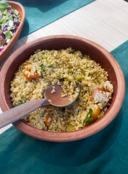 istock Bulgur cooked with green pepper, onion and parsley in a ceramic bowl on the table during dinner. Homemade dishes. The concept of traditional Turkish cuisine. Vertical orientation. 2170536144