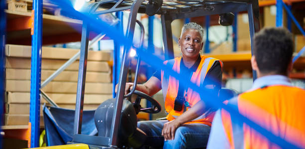 istock senior female fork lift operator chatting to colleague 2170537107