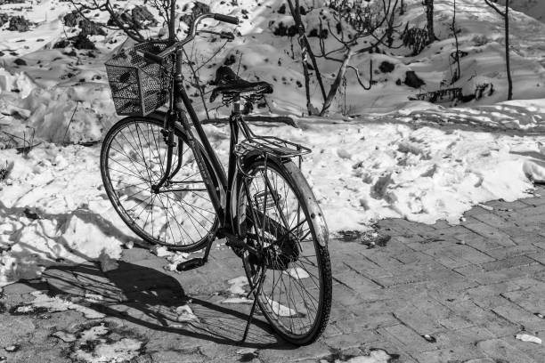 A bicycle parked on a pathway by a snow pile, Kashgar, Xinjiang, China