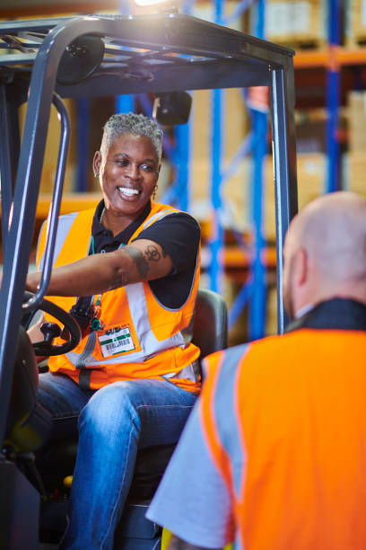 istock senior female fork lift operator chatting to colleague 2170537462
