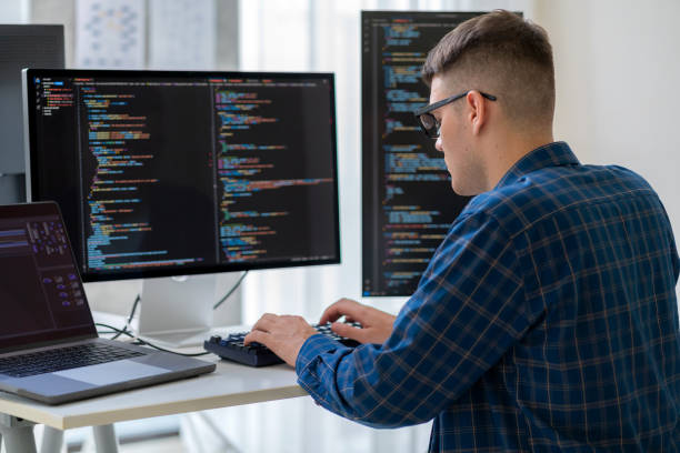 istock Empowered specialists, IT professionals, work late in a high-tech research center, focused on developing advanced software, artificial intelligence interfaces, and cloud computing solutions with coding. Seated at desks with laptops and multiple screens. 2170543832