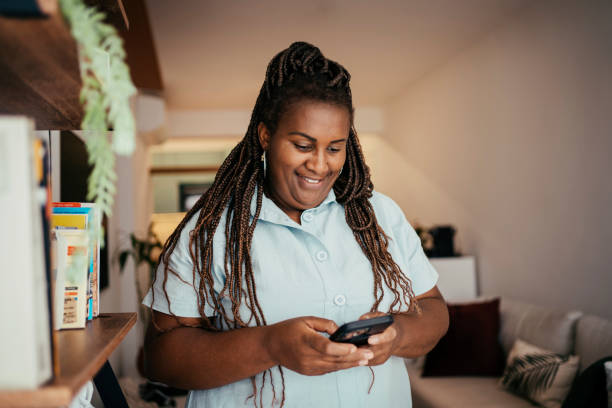 istock Black woman using smart phone at home 2170544604