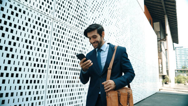 istock Professional manager looking at mobile phone while walking at street. Exultant. 2170545453