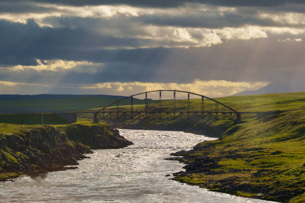 istock Sun rays over a metal bridge crossing a river in Iceland 2170549069