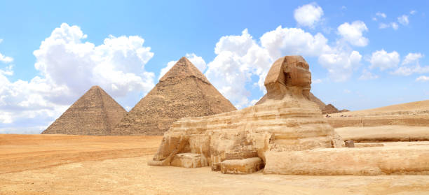 istock Famous Great Sphinx and pyramids of Chephren and Cheops, Cairo, Egypt. Great Pyramids and ancient statue of Sphinx, mythical creature with head of man and body of lion, Giza complex (Giza Necropolis) 2170559279