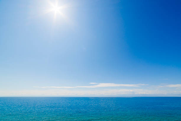 large open water surface with far snowcapped mountain range on the horizon at sunny day.