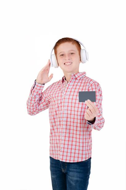 Happy young boy in yellow outfit and shades posing confidently with headphones, vibrant yellow backdrop.