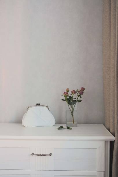 istock An Elegant White Purse Adorned with Fresh Flowers Gracefully Placed on a Minimalist Table 2170563221