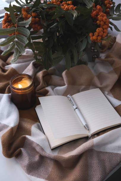 istock A Cozy Autumn Setting Featuring a Journal, Flickering Candle, and Beautiful Flowers 2170563257