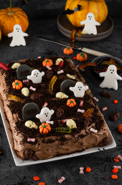 istock Halloween chocolate cake. Dirty cake with chocolate cream, decorated with worms, skulls, ghosts, pumpkins and sugar sprinkles on a dark background. 2170564953