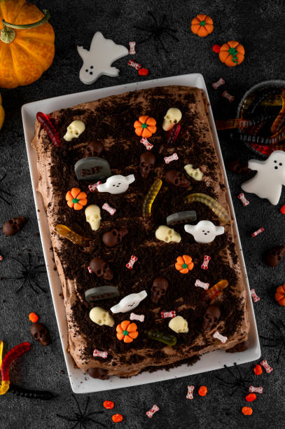 istock Halloween chocolate cake. Dirty cake with chocolate cream, decorated with worms, skulls, ghosts, pumpkins and sugar sprinkles on a dark background. 2170564954