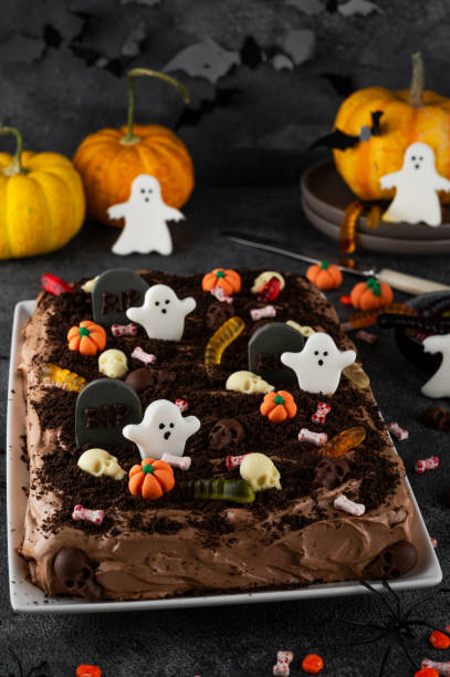istock Halloween chocolate cake. Dirty cake with chocolate cream, decorated with worms, skulls, ghosts, pumpkins and sugar sprinkles on a dark background. 2170564982