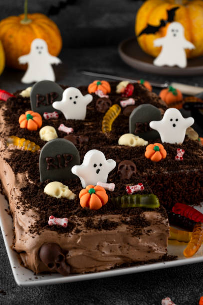 istock Halloween chocolate cake. Dirty cake with chocolate cream, decorated with worms, skulls, ghosts, pumpkins and sugar sprinkles on a dark background. 2170564985