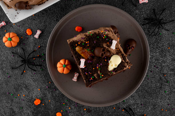 istock Halloween chocolate cake. Dirty cake with chocolate cream, decorated with worms, skulls, ghosts, pumpkins and sugar sprinkles on a dark background. 2170564996