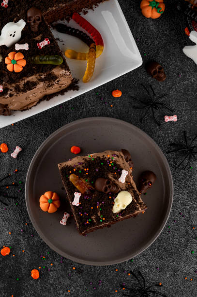 istock Halloween chocolate cake. Dirty cake with chocolate cream, decorated with worms, skulls, ghosts, pumpkins and sugar sprinkles on a dark background. 2170564997