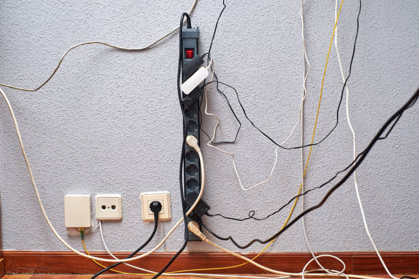 istock Tangled cords and power strips cluttering a wall in a modern workspace during daylight hours 2170565584