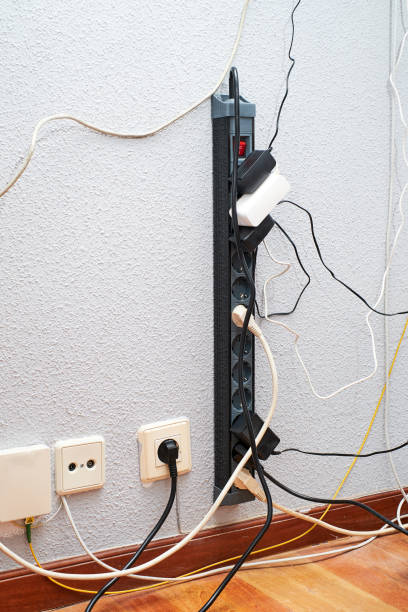 istock Tangled wires and power strip against a wall in a home office during daylight hours 2170565605