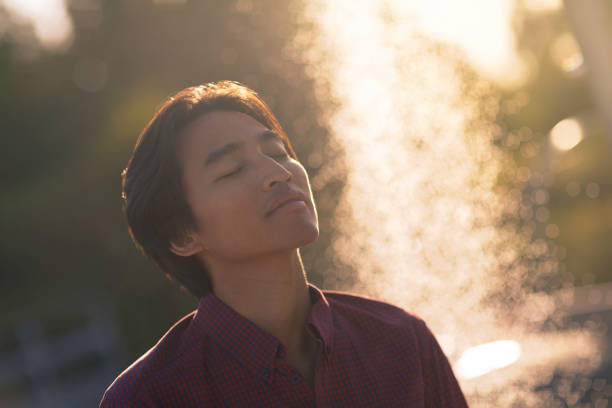 istock Man enjoying a moment alone in a park with a fountain 2170566610