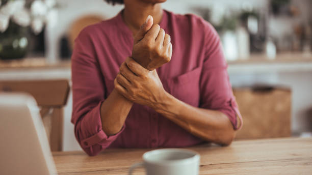 istock Woman Suffering Wrist Pain While Sitting at Home Table 2170566906