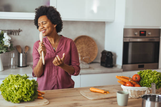 istock Joyful Woman Singing With Spoon in Modern Kitchen 2170566988