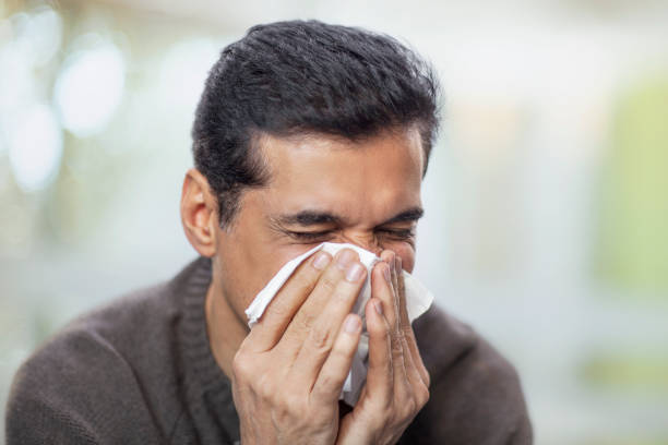 istock Mature man blowing nose in home interior environment 2170567328