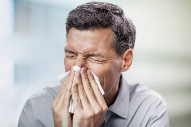 istock Mature man blowing nose in office space interior 2170567391