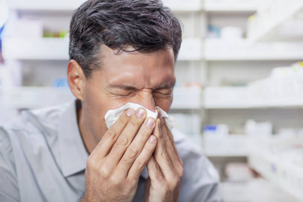 istock Mature man blowing nose in medical pharmacy interior 2170567449