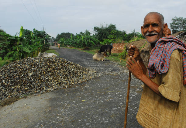 Poor Indian man standing on a street and asking for support.