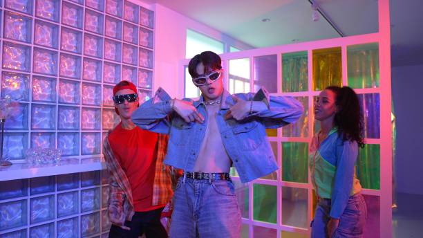 istock Asian man moving arm while dancing with diverse team in neon light. Regalement. 2170570253