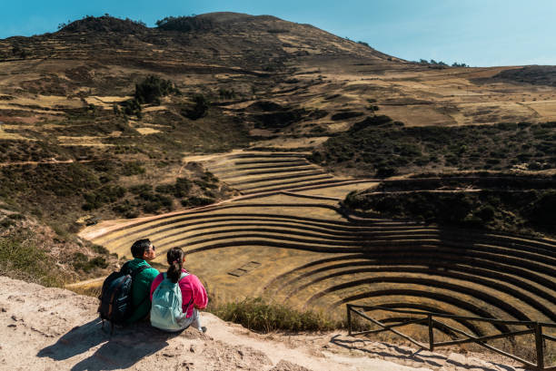 Couple looking at view on a mountain, in Moray, Peru