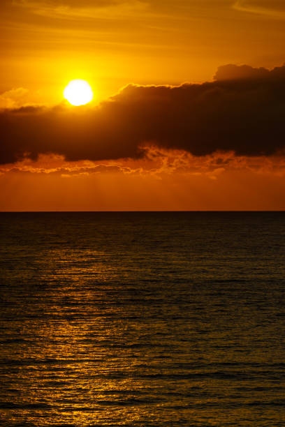 Seascape. Sunrise over sea water. Sun rising above horizon.