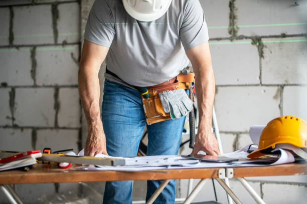 istock Unrecognisable handyman reviewing architectural blueprints at the table with construction work tools at site 2170584444